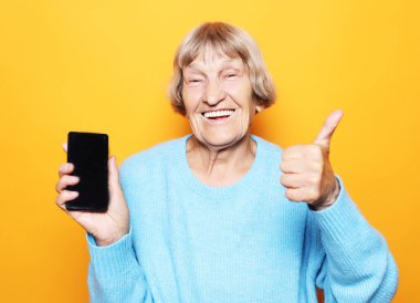 Yeni akıllı telefonlu olgun bir kadının resmi..
