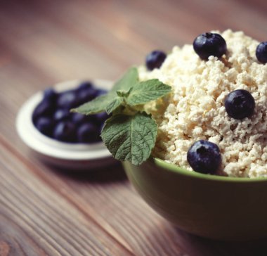 Süzme peynir ve yaban mersini ve nane bir tabloda bir kasede.