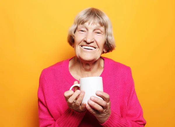 Portrait of old excited lady smiling laughing, holding cup drinking coffee, tea — Stock Photo, Image