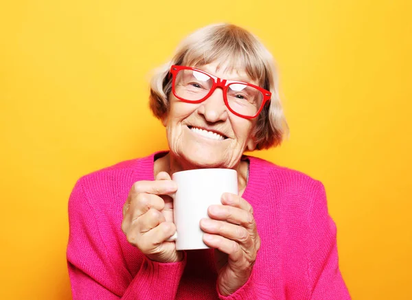 Retrato de velha senhora excitada sorrindo rindo, segurando xícara beber café, chá — Fotografia de Stock