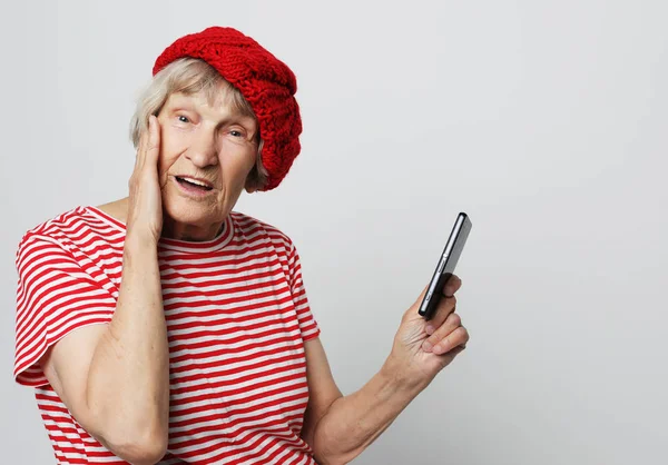 Vecchia nonna guarda il suo smartphone ed è sorpreso — Foto Stock