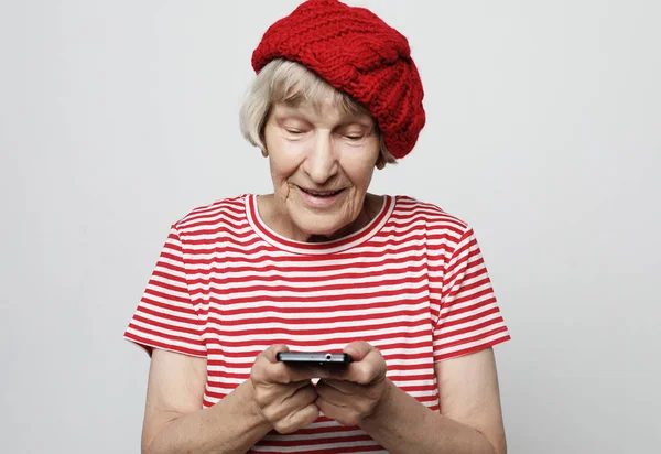 Vecchia nonna sta parlando con i suoi nipoti per telefono, sorridendo e salutandoli. — Foto Stock