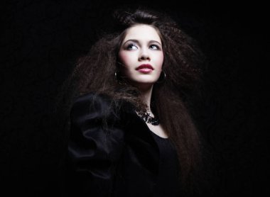 Kıvırcık saçlı ve akşam makyajlı güzel bir kadın. Mücevher ve Güzellik konsepti.