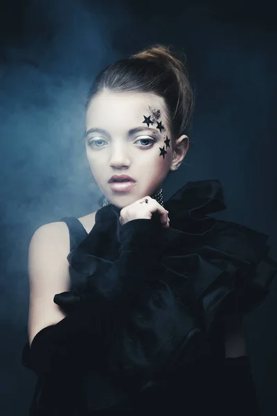 Concepto de belleza y moda: Niña vestida de negro. Maquillaje creativo . — Foto de Stock