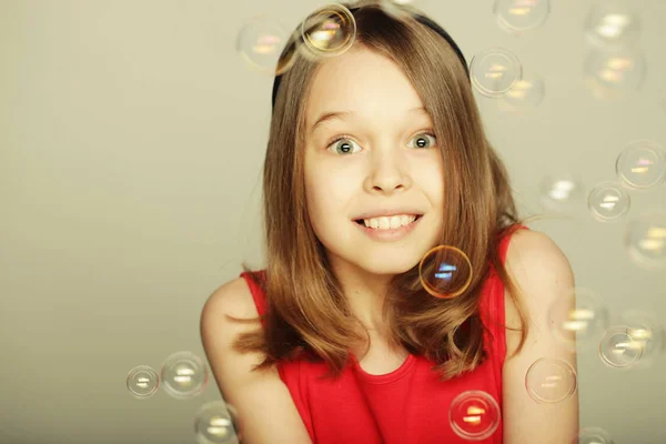 Mała dziewczynka dmuchanie bańki mydlane — Zdjęcie stockowe