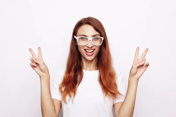 Portrait de femme magnifique regardant la caméra avec le sourire et montrant signe de paix avec les doigts — Photo