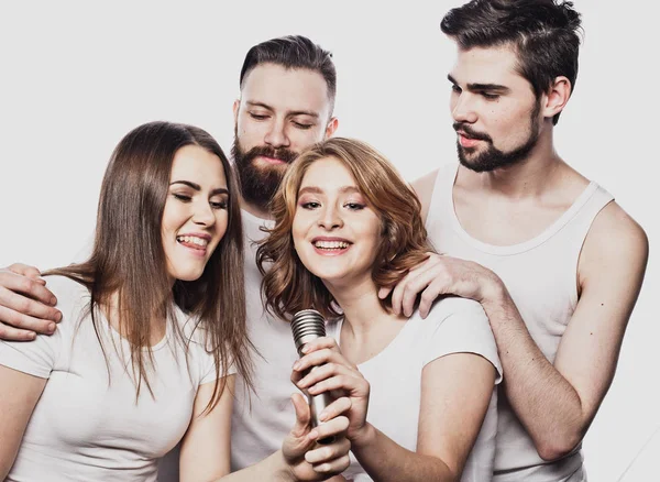 Grupo de amigos jogando karaoke sobre fundo branco. Conceito sobre amizade e pessoas . — Fotografia de Stock