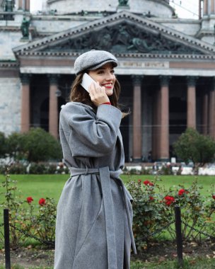 Arama ve smartphone sonbahar City'deki konuşurken genç gülümseyen