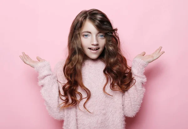Schöne lockige Mädchen in lässiger Kleidung suchen Kamera und lächeln isoliert über rosa Hintergrund — Stockfoto
