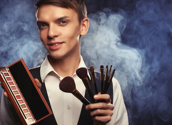 Professional makeup artist posing in studio, holds a palette — Stock Photo, Image