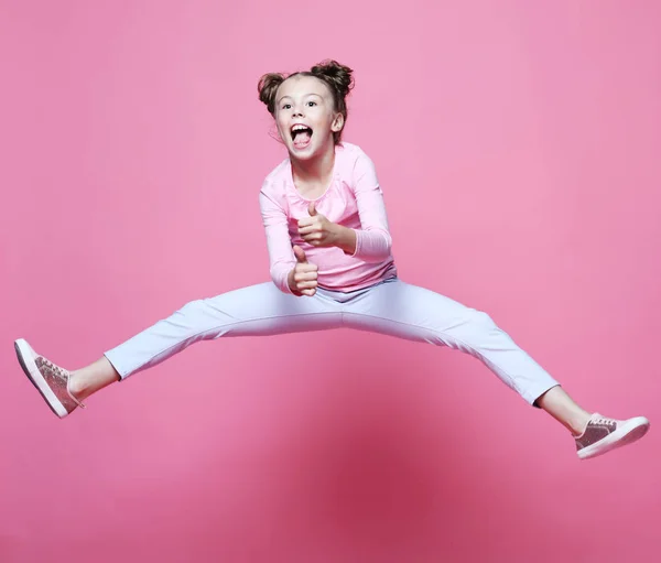 Divertente bambino ragazza vestito casual salto su sfondo rosa — Foto Stock