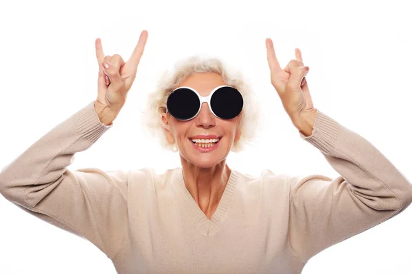 Senior woman wearing big sunglasses doing funky action isolated — Stock Photo, Image