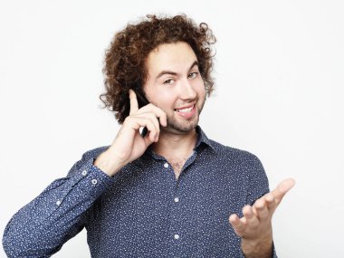 Üzerinde telefon duran parmak ile ok işareti yapıyor beyaz arka plan üzerinde konuşan genç yetişkin adam