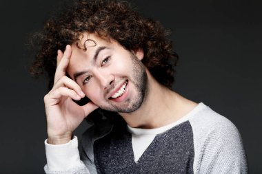 yaşam tarzı, duygu ve insanlar kavramı: kafasını dokunmaktan ve gülümseyen yakışıklı delikanlı