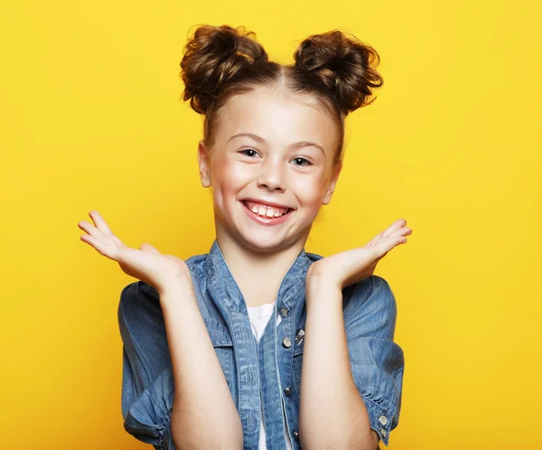 Sarı arka planda gülümseyen küçük kız portresi — Stok fotoğraf