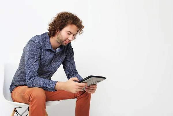 Счастливый случайный человек на стуле с планшетным компьютером — стоковое фото