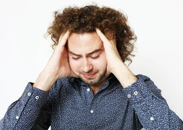 Close up of frustrated young man with head in hand — Stock Photo, Image