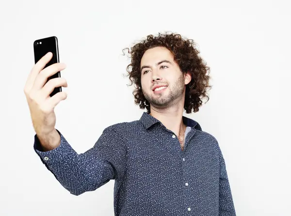 Porträt eines fröhlichen Mannes, der ein Selfie vor weißem Hintergrund macht — Stockfoto