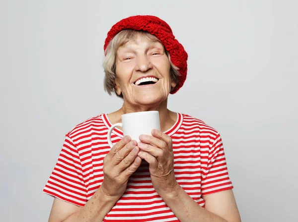 Stary podekscytowany lady uśmiechając się, trzymając filiżankę picia kawy — Zdjęcie stockowe