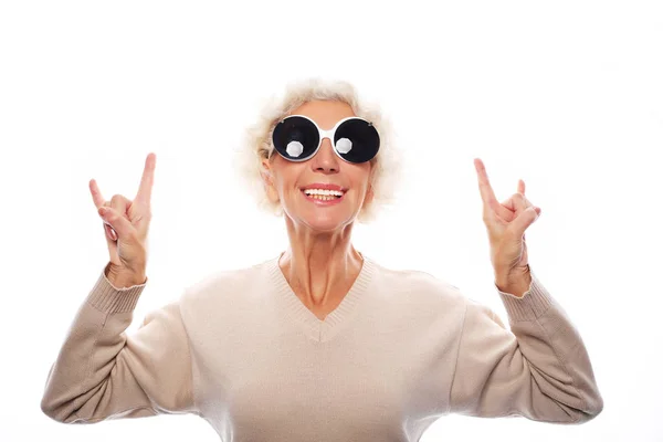 Ηλικιωμένη γυναίκα που φοράει μεγάλα γυαλιά ηλίου κάνει funky δράση — Φωτογραφία Αρχείου