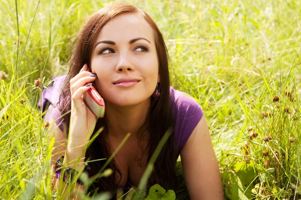 Pretty woman outdoor in the grass in summertime — Stock Photo, Image