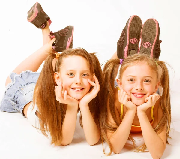 Duas meninas bonitas que colocam no branco — Fotografia de Stock