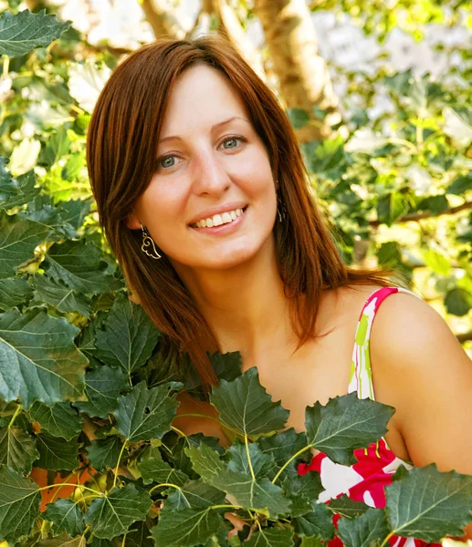 Woman sitting outdoors smiling — Stock Photo, Image