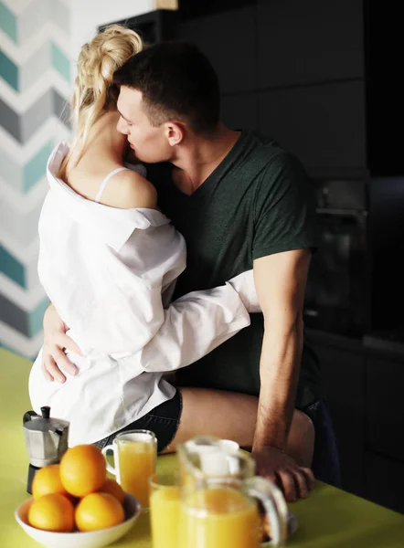 Kedves fiatal pár áll és ölelkezik otthon a konyhában. — Stock Fotó