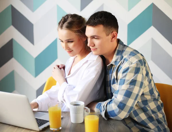 Loving couple having breakfast and looking at laptop computer — Stock Photo, Image