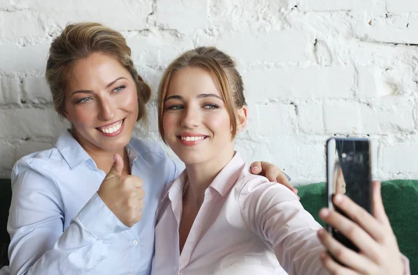Mogen mamma och hennes dotter gör en selfie med hjälp av smarttelefon — Stockfoto