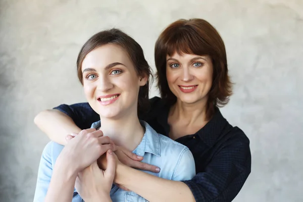 Glückliche Seniorin umarmt erwachsene Tochter und lacht miteinander — Stockfoto