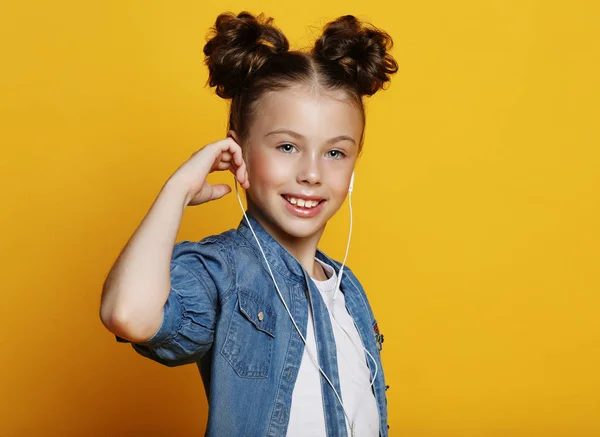 Sorridente bambina in abiti casual su sfondo giallo — Foto Stock