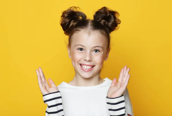 Sarı arka planda gülümseyen küçük kız portresi — Stok fotoğraf