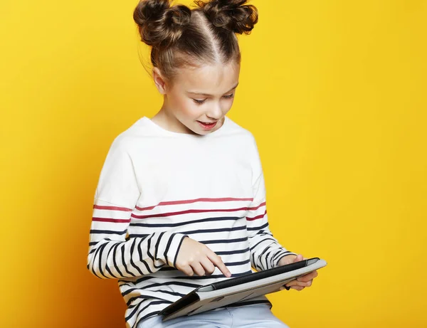 Κοριτσάκι με tablet σε φόντο κίτρινο studio. — Φωτογραφία Αρχείου