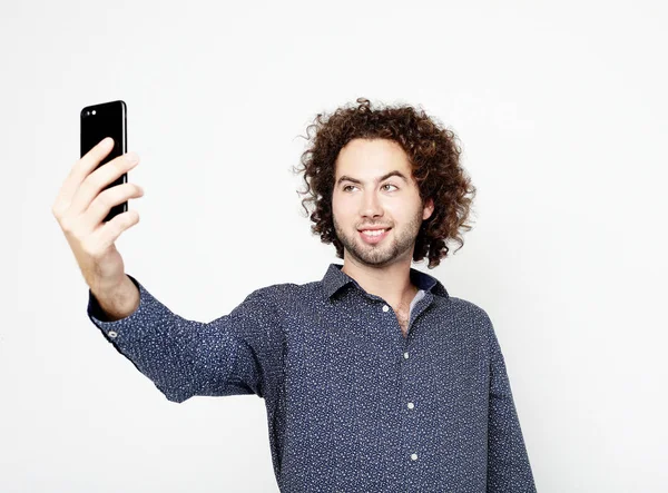 Porträt eines fröhlichen Mannes, der ein Selfie vor weißem Hintergrund macht — Stockfoto