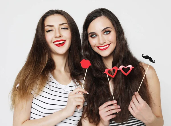 Två snygga sexiga tjejer bästa vänner som håller pappersfest pinnar — Stockfoto