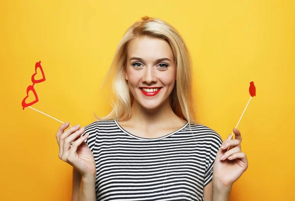 Playful young woman ready for party over yellow background — Stock Photo, Image