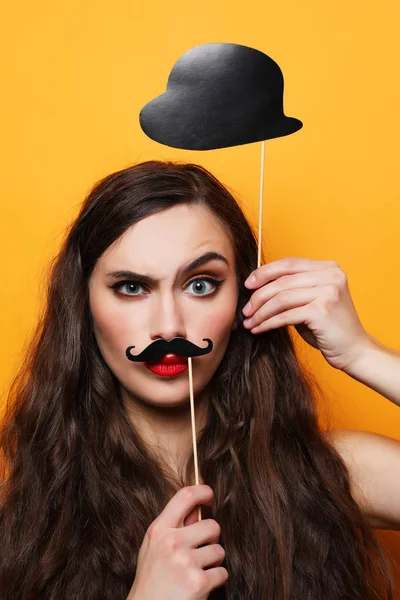 Playful young woman ready for party over yellow background — Stock Photo, Image