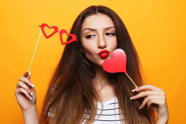 Playful young woman ready for party over yellow background — Stock Photo, Image