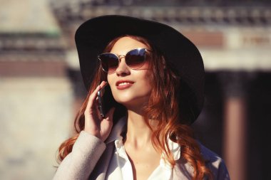 Arama ve smartphone sonbahar City'deki konuşurken genç gülümseyen