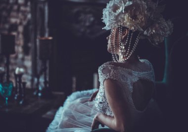 Güzel gelin bir sandalyeye oturur. Lüks Sarayı.