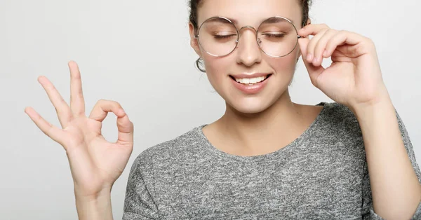 Studentessa positiva indossa maglione grigio, occhiali rotondi.Persone — Foto Stock