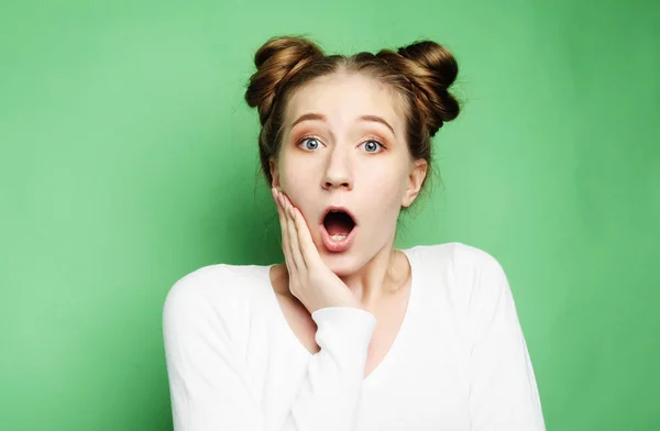 Estilo de vida y el concepto de la gente: Mujer joven sorprendida gritando sobre fondo verde —  Fotos de Stock