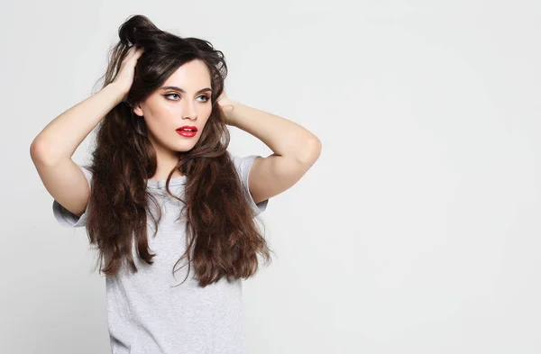 Hermosa mujer vistiendo ropa casual, posando sobre fondo blanco — Foto de Stock