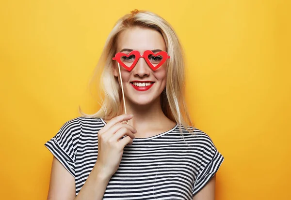 Playful young woman ready for party over yellow background — Stock Photo, Image