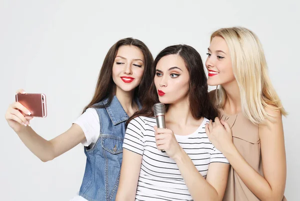 Due ragazze di bellezza con un microfono scattare selfie con smartphone — Foto Stock