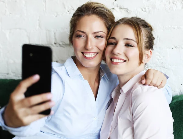 परिपक्व आई आणि तिची मुलगी स्मार्ट फोन वापरून सेल्फी बनवणे — स्टॉक फोटो, इमेज