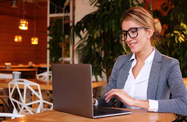 Fiatal üzletasszony használ a laptop a kávézóban. Életmód és az üzleti koncepció. — Stock Fotó