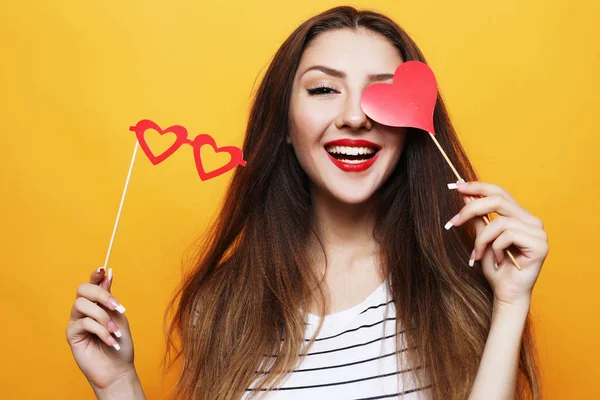 Speelse jonge vrouw klaar voor partij op gele achtergrond — Stockfoto