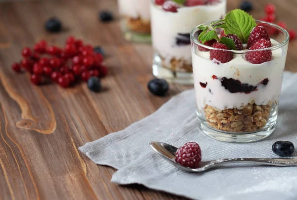 Fröhliches Frühstück - Joghurt mit Müsli und Beeren auf einer Holzlasche — Stockfoto